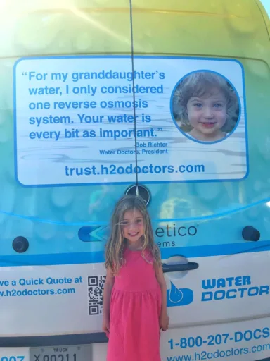 Young girl standing next to photo from a testimonial