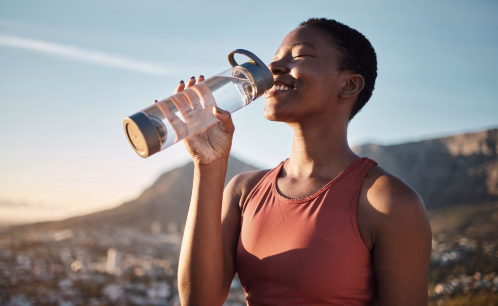 Healthy woman enjoying clean, great-tasting water after filtration, representing benefits of reverse osmosis systems.
