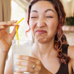 Woman reacting to bad-smelling well water in a glass